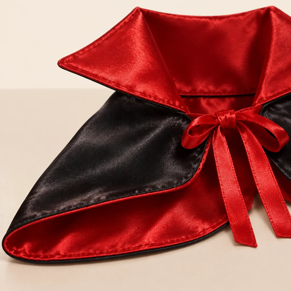 The exact PetJoy vampire cape: black satin-like outer panels (#111111), deep red satin lining and ra
