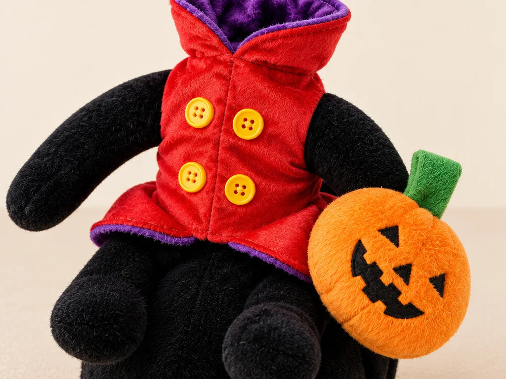The exact pumpkin-rider costume from ref r16 is the subject: black plush base, red-and-black plush r