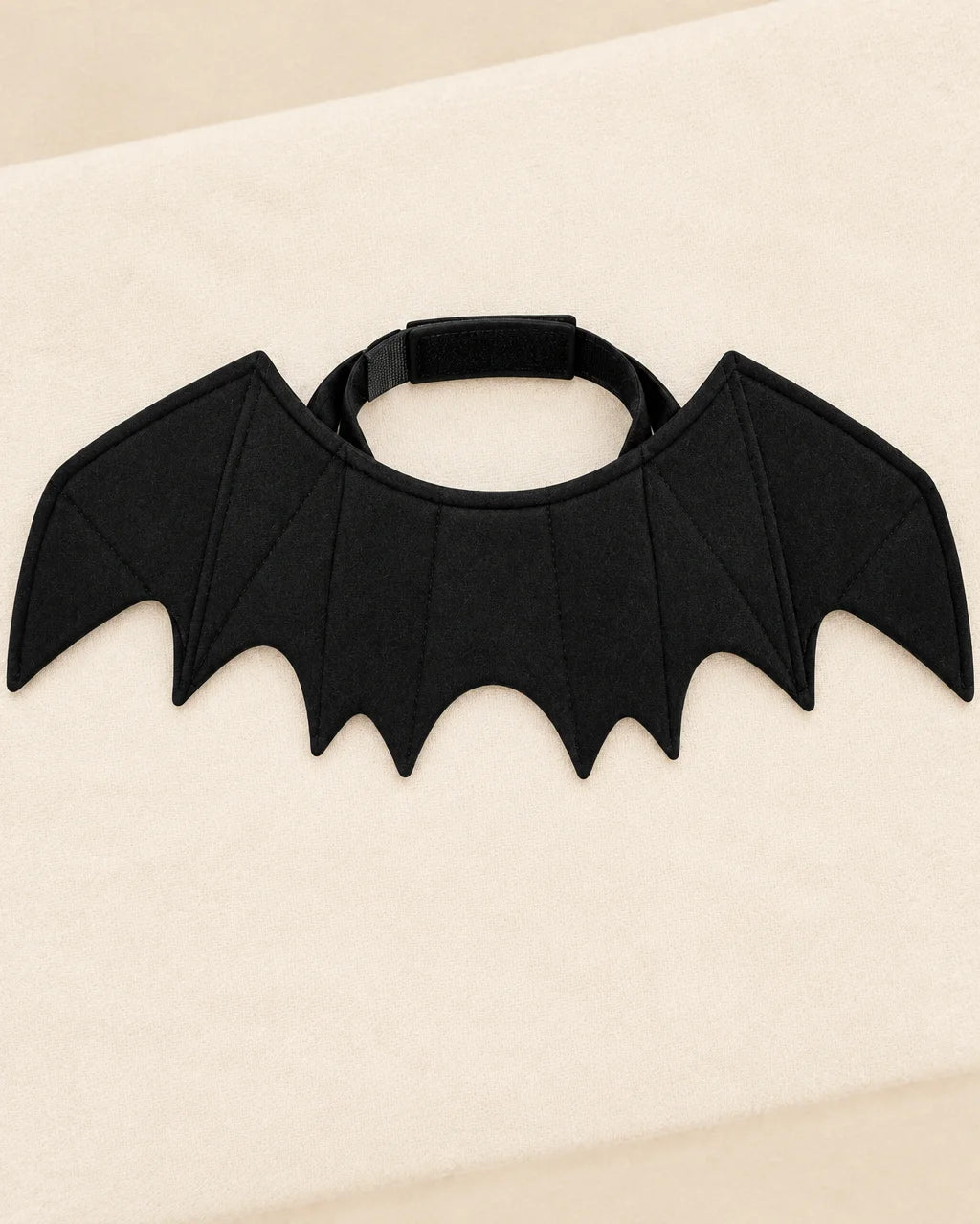 The exact black bat-wing costume from ref r18 is the subject: soft matte fabric wings with visible s